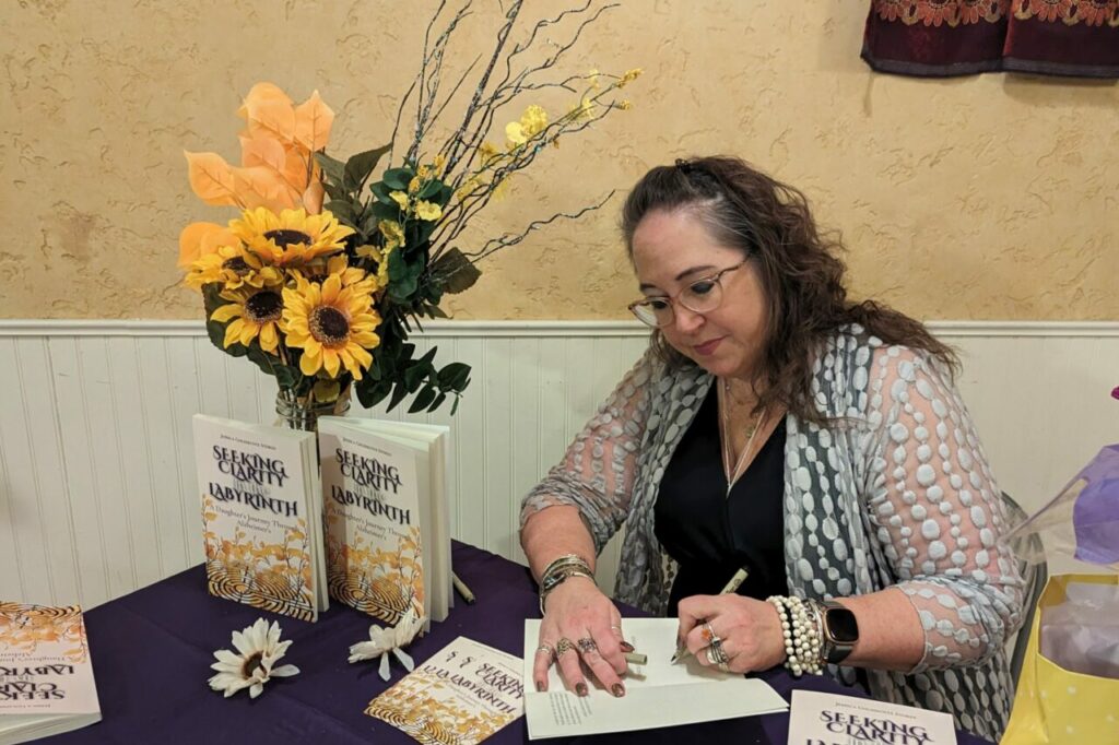 Author and teach Jessica Stokes signing her book Seeking Clarity in the Labyrinth.